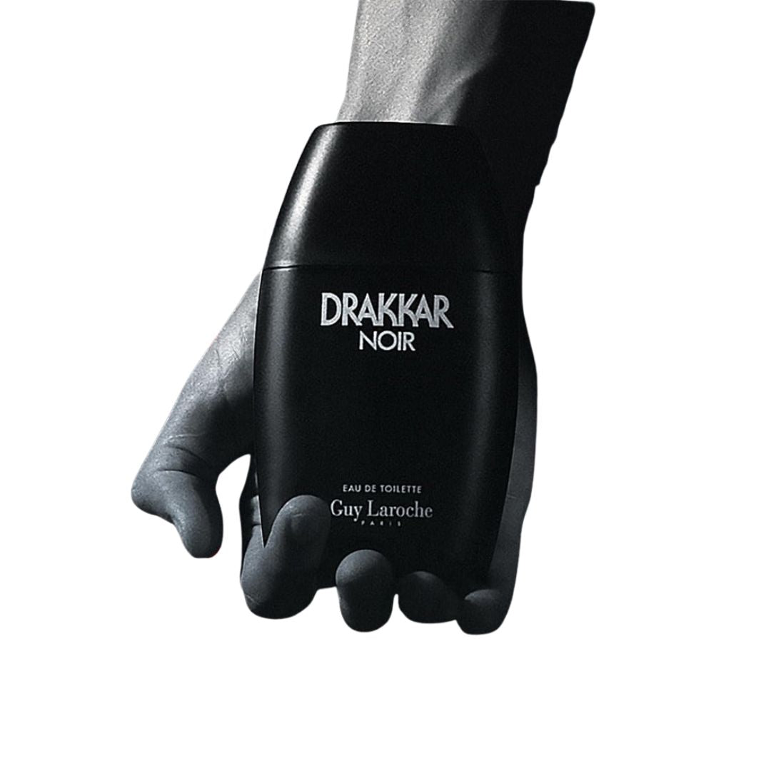 Black Drakkar Noir Guy Laroche perfume bottle held by a hand on a white background