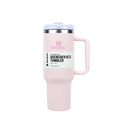 Pink Stanley tumbler with a handle on a white background