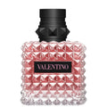 Valentino perfume bottle with pink textured design and black cap on a white background